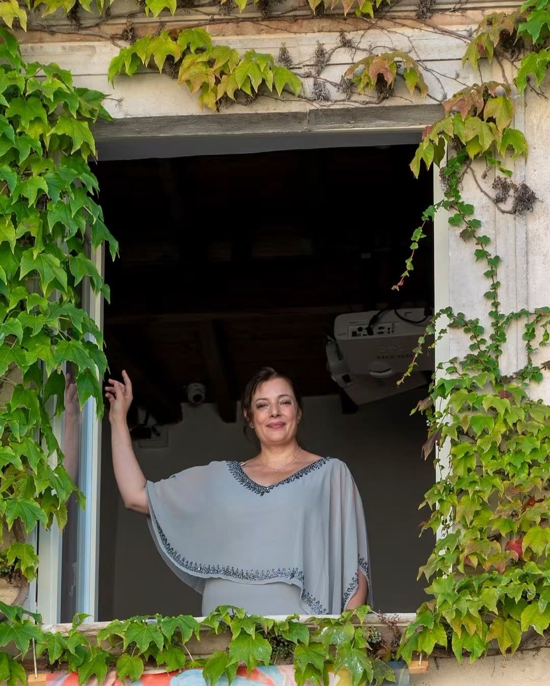 Vanessa Ayllón ante una ventana enmarcada por la hiedra en Casa Menotti, Spoleto